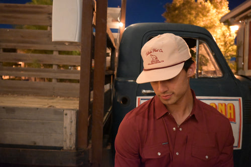 Toledo Hat Co. Pale Peach and Maroon Coyote Hat – lifestyle shot outdoors